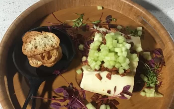 A plate of food on a table next to a bowl of food