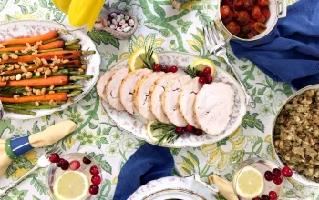 Sliced turkey roast placed on a table which is decorated with different food delicacies.