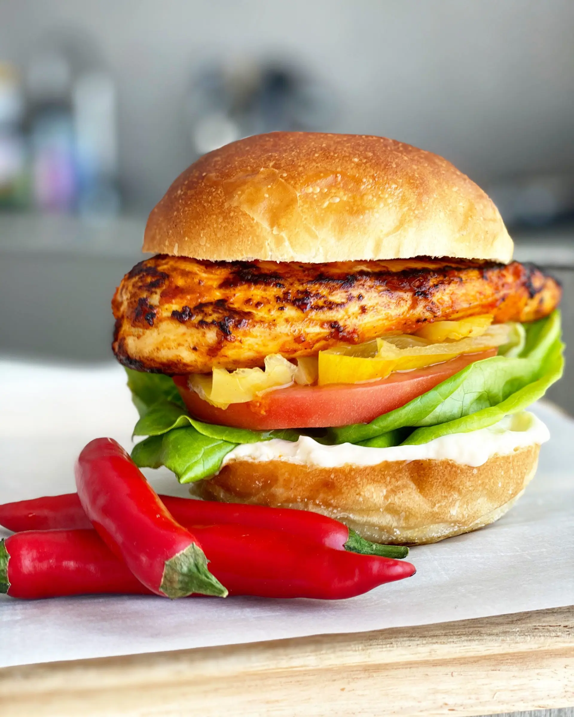 Peri peri burger with red peppers on the side.