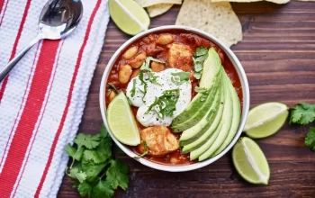 Turkey chili topped with avocado, yogurt and lemon served in a bowl.