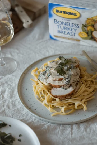 Rôti de dindon avec sauce crémeuse aux agrumes et à l’ail servi sur des pâtes