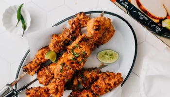Butterball tandoori turkey kebabs with lemon on the side placed in a tray.