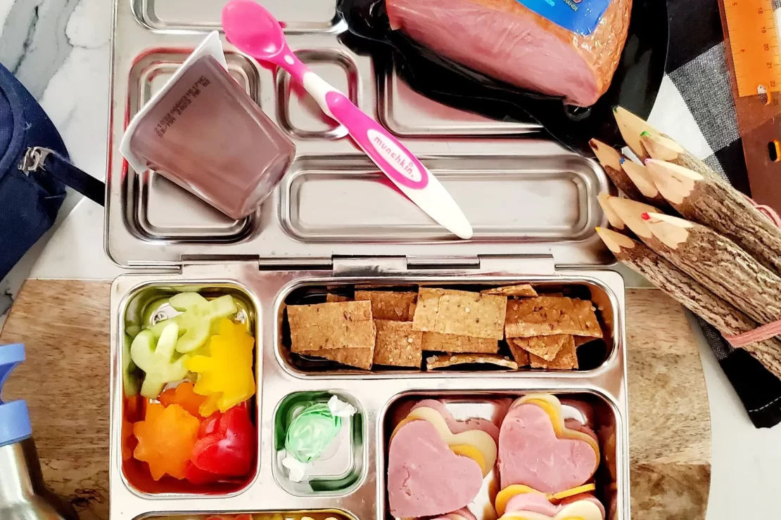 Lunch box for kids with assorted food items including turkey ham.