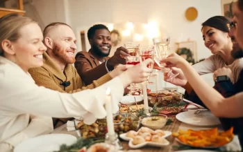 Several individuals raising their glasses in celebration during a Christmas dinner.