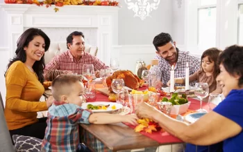 A family gathered around a table, celebrating Thanksgiving with a delicious meal and warm smiles.